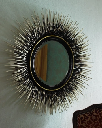 Круглое зеркало в черной раме "Ларс" - это необычное настенное зеркало с лучистыми рядами черных перьев разного размера, которые плавно переходят в белый цвет, что придает зеркалу текстуру и глубину.